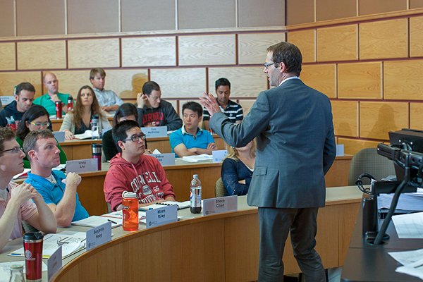 Photo of a professor teaching at the front of a lecture hall