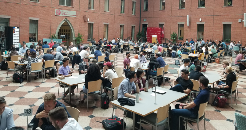 Photo of a packed Dyson Atrium with students working at tables