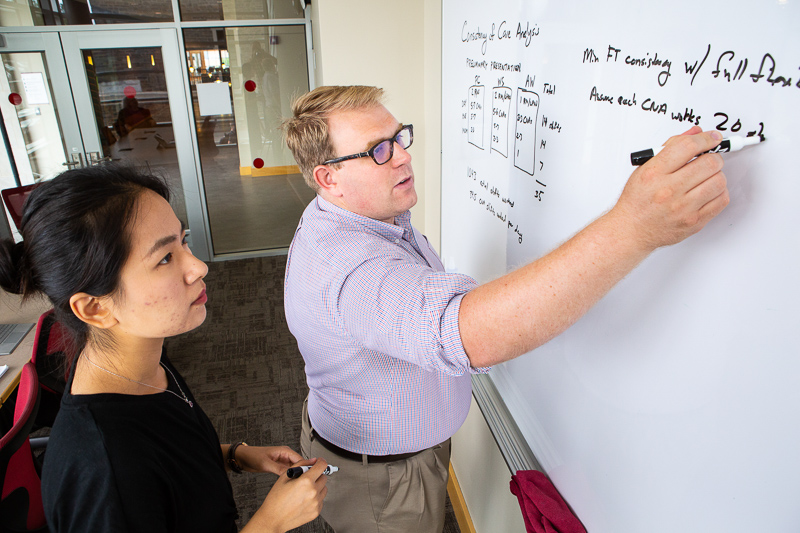 Photo of Vince and Issy working at a whitboard