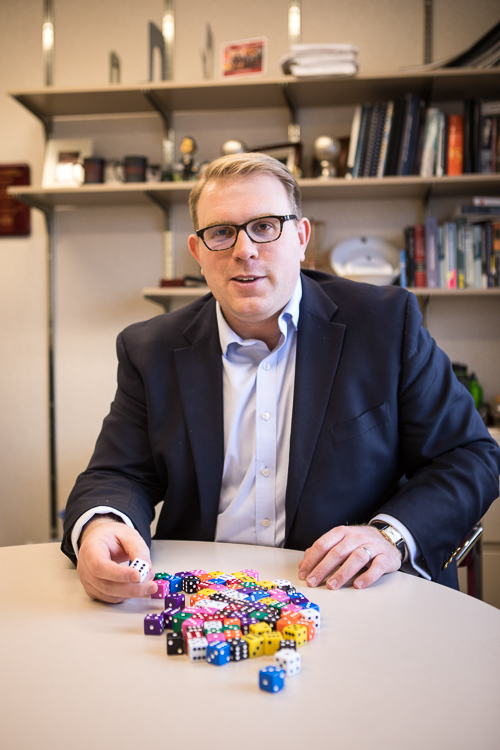 Photo of Vince Slaugh seating with a pile of dice on the table