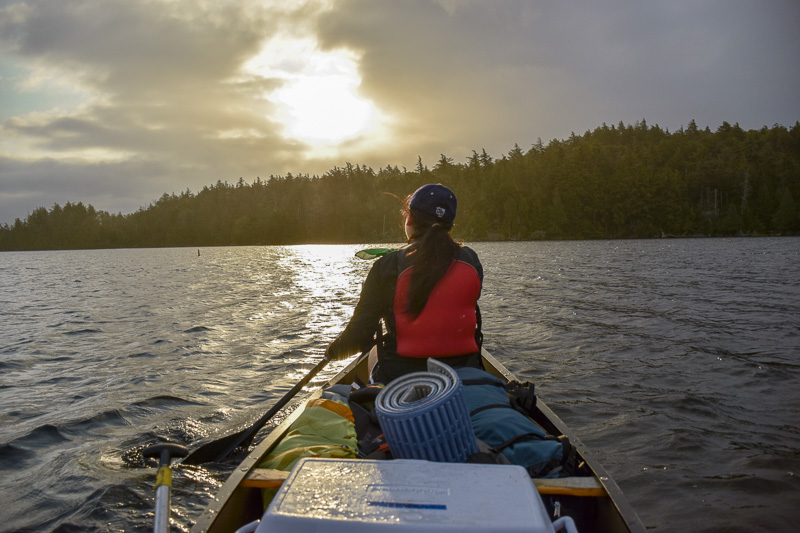 Girl paddling a canoe on a lake