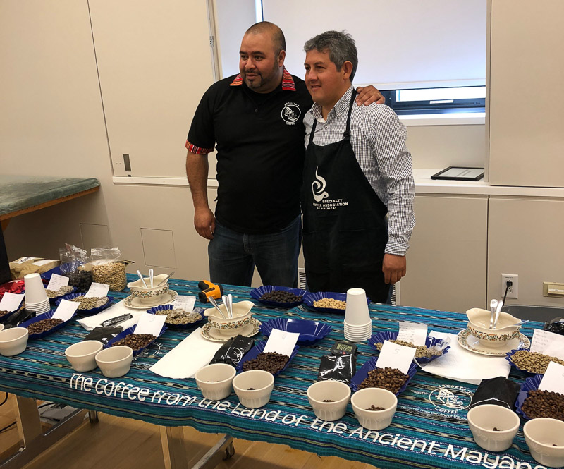 Argueta and Lopez behind their table at the coffee tasting event