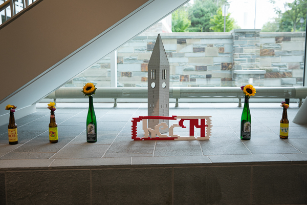 Photo of flowers, a miniature Cornell clock tower, and Legos that spell out HEC 94