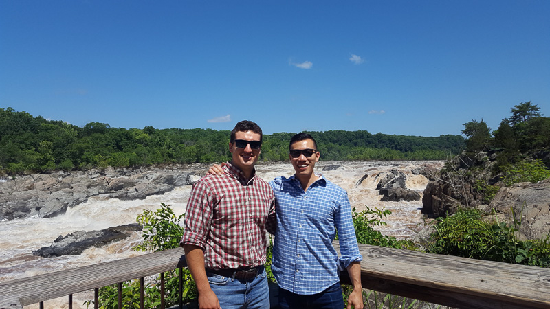 Keith and his co-consultant standing on a deck overlooking a section of rapids