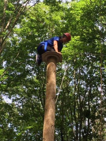 Photo of Emily Voo, PF '19, climbing an obstacle at the ropes course
