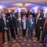 A group standing side-by-side in the meeting room