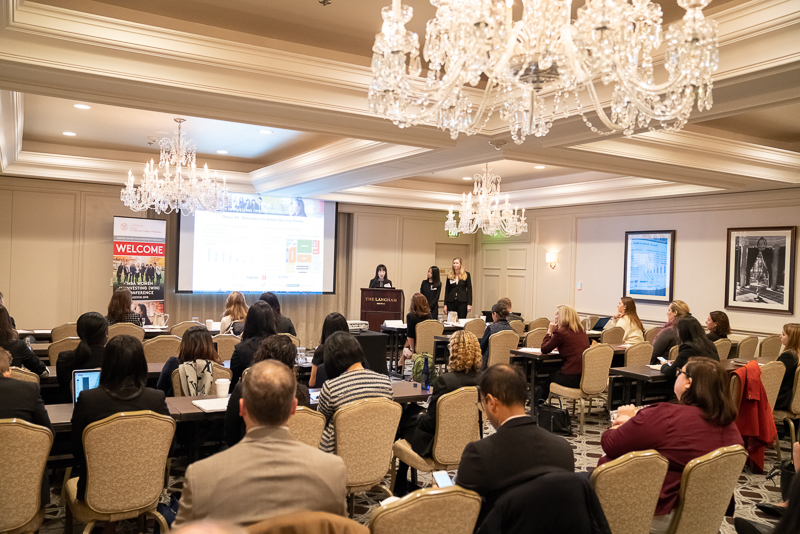 A team presents at the front of a crowded room