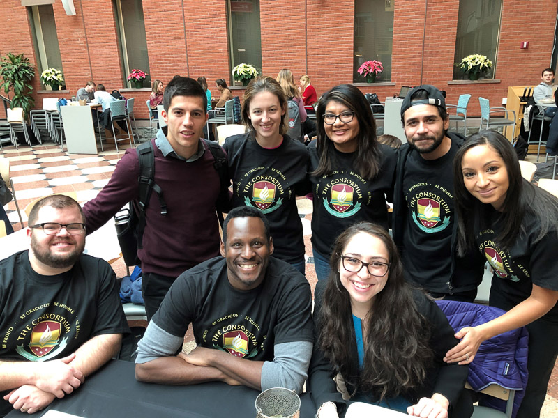 Consortium students at a table with matching shirts