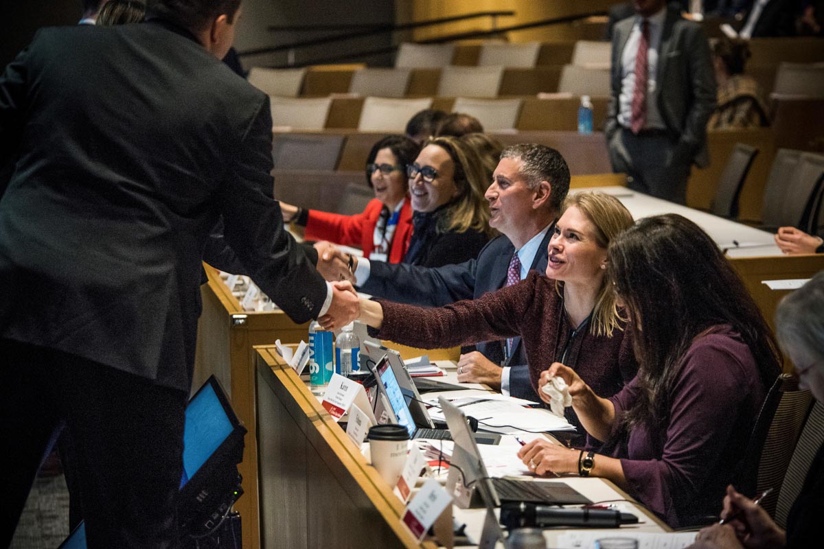 Students shaking hands across the judge's panel