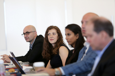 Five people talking while seated at a table