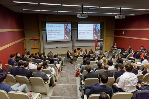 An auditorium of guests and a panel