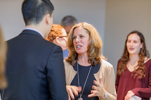 A woman talks with students