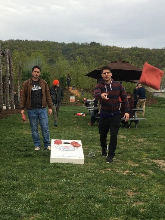 Two men play corn hole