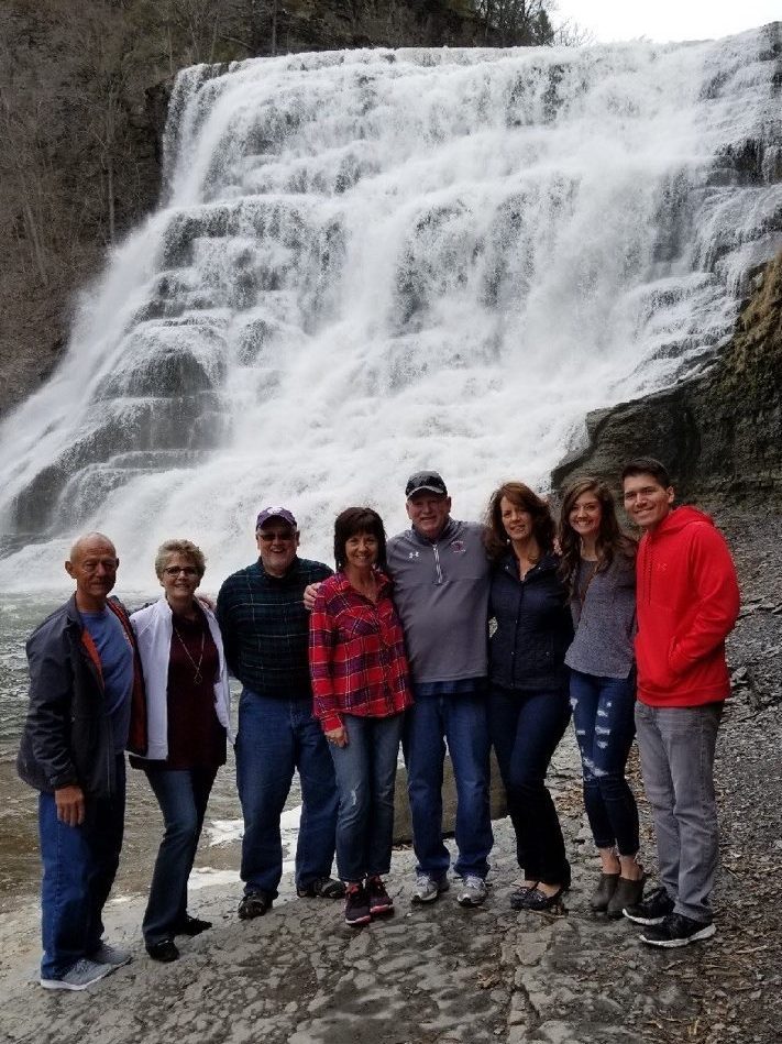 A groups stands in front of a waterfall