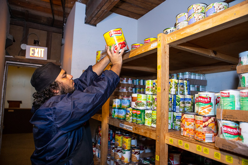 Student putting cans on a shelf