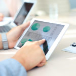 Business person analyzing financial statistics displayed on the tablet screen