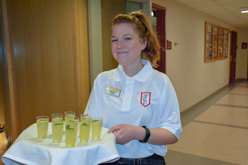 A student holding a tray of drinks