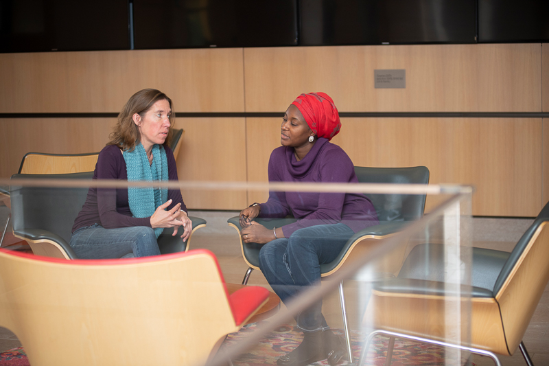 Joanna and Khadijat talk while seating in a lobby