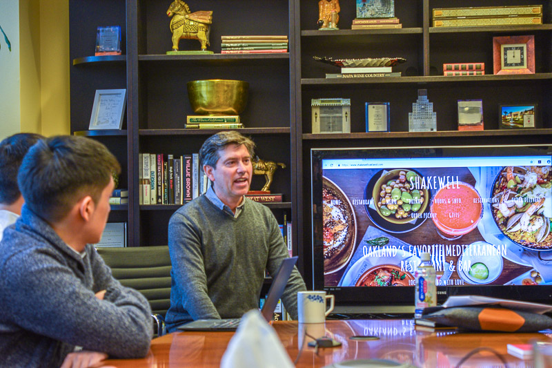 Robert sits at a table with a presentation next to him