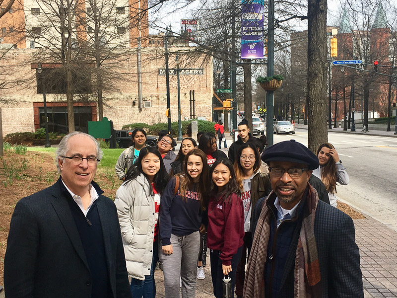 A group walks down the street and poses for a selfie