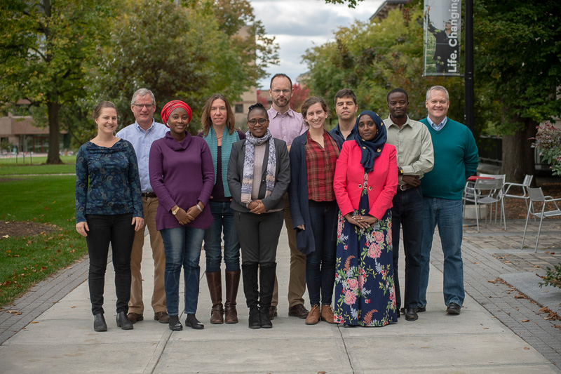 11 people pose for a photo outside