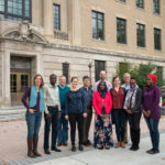 A group stands outside Warren Hall
