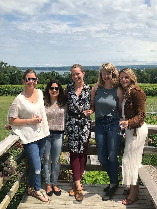 Five women standing on a porch overlooking a field