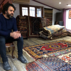 A man sitting in a rug shop