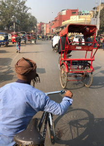 A street cart and man on a bicycle