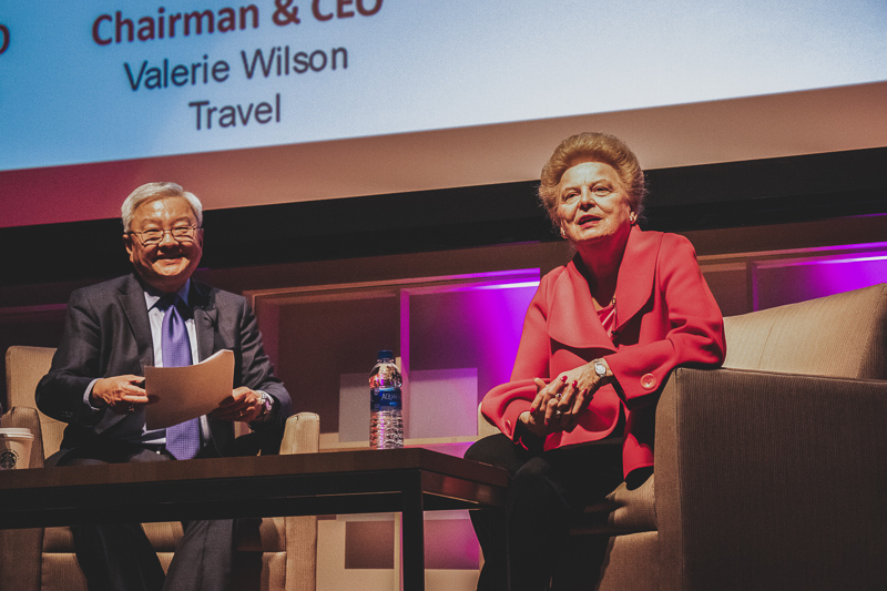 Valerie sits on stage with a moderator