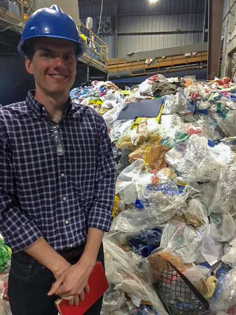 Matt stands in front of a huge pile of plastic bags