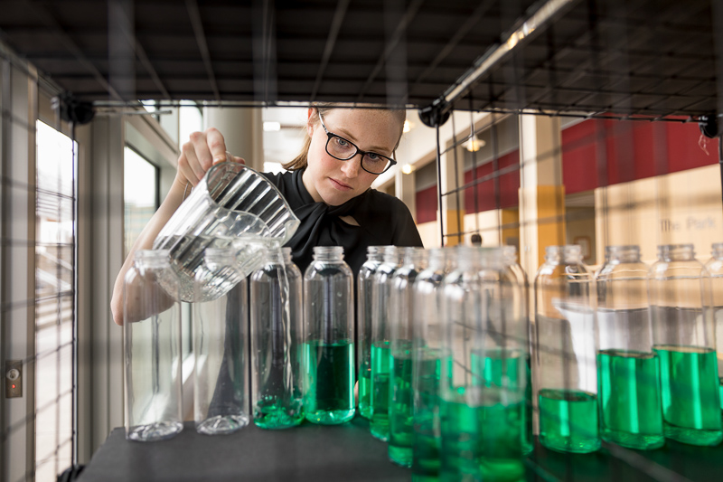 Kyra pours green drinks