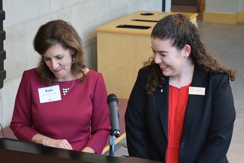 Kate and Megan stand at a podium