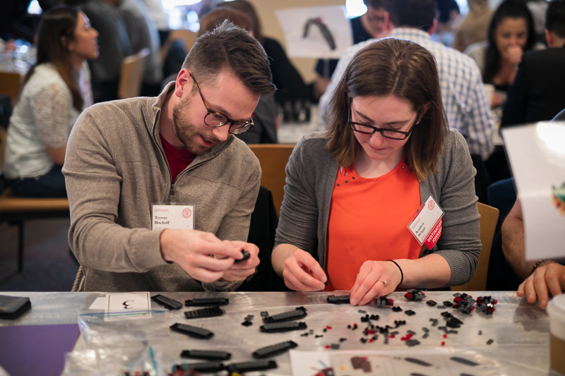 Two people comparing lego models