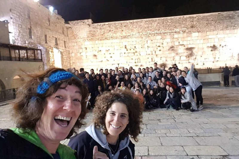 Tour guides and the group take a selfie with the Western Wall