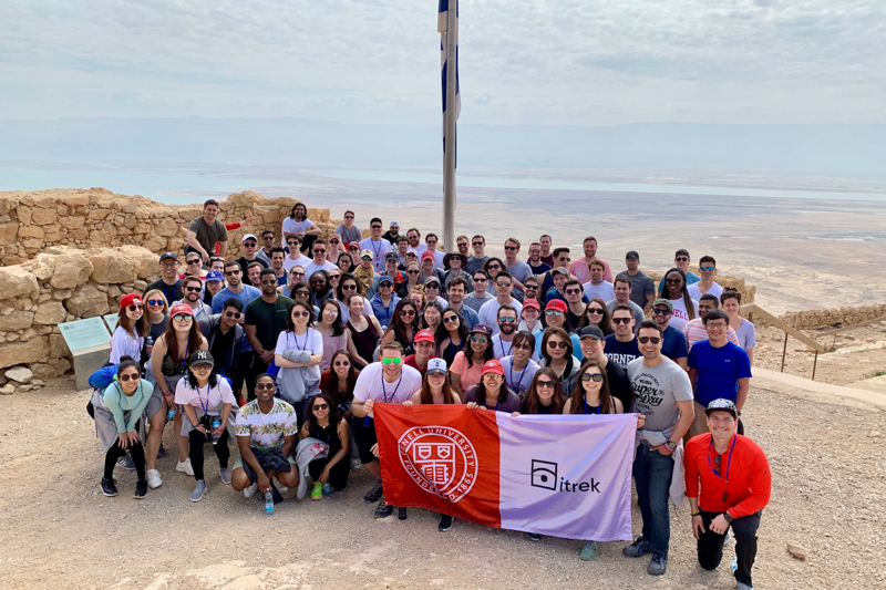 Large group of students holding a Cornell iTrek banner