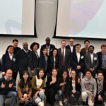 Large group photo at the front of the lecture hall