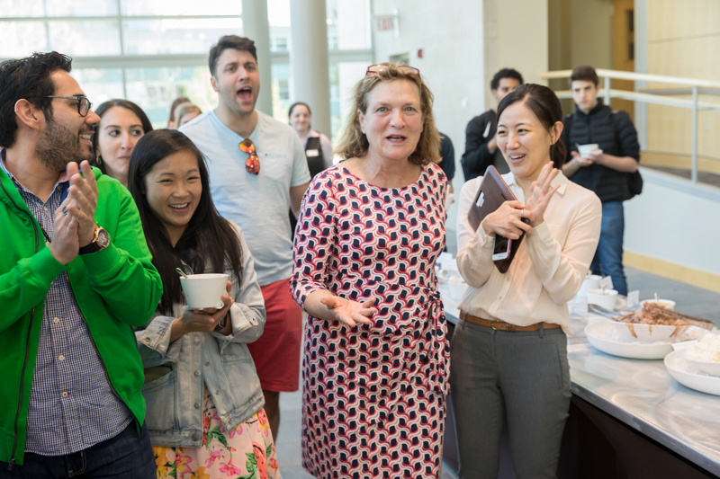 Linda laughing surrounded by a group of people