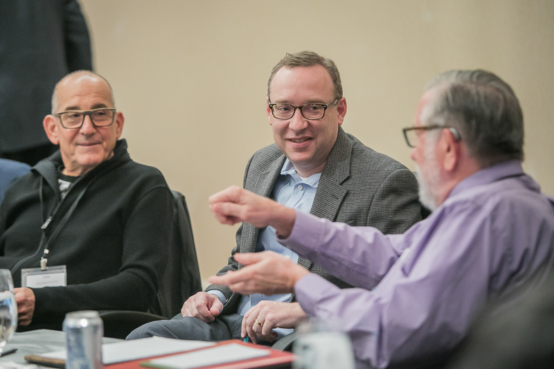 Three men sitting at a table