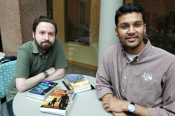 David and Nitin sit with Larson books in Sage Hall