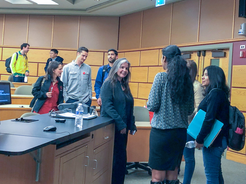 Niki and students stand at the front of a classrroom