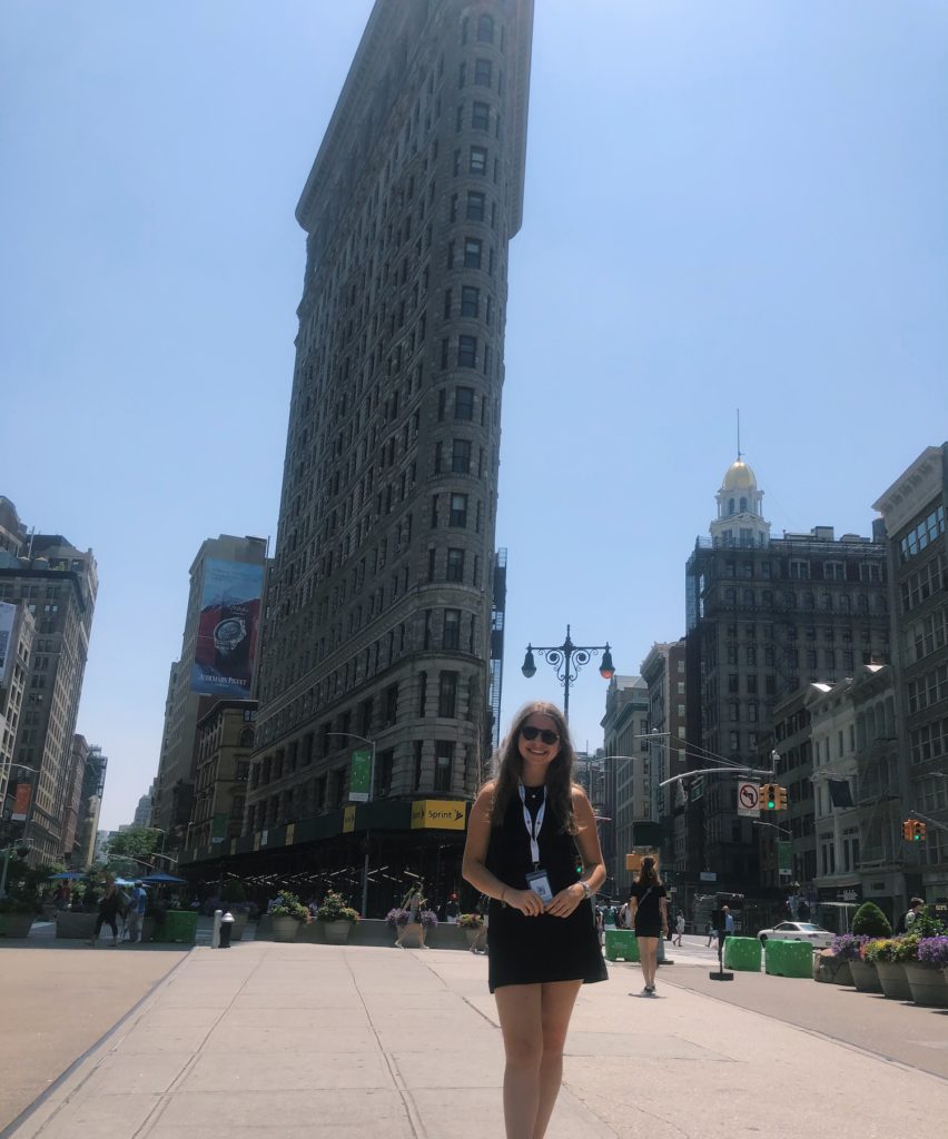 Carly standing outside the tall Eataly buidling