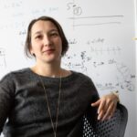Elena Belavina in front of a whiteboard of calculations