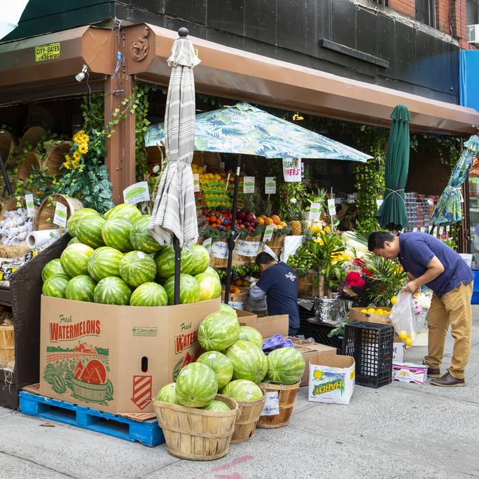 Man buying lemons at a neighborhood market in NYC