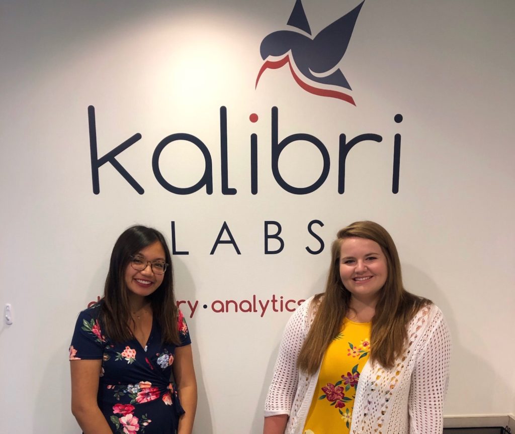 Michelle and Kristen standing in front of the Kalibri logo