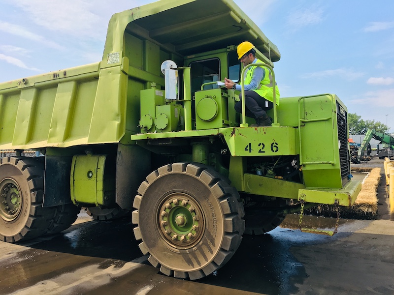 Nikunj sitting in a large green truck