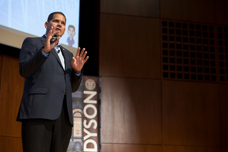 Reggie presents with his meme on the screen behind him