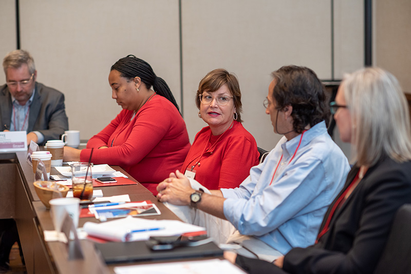 Jennifer Robinson seated at a table with other participants