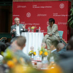 Larry Ruff and Cynthia Saunders-Cheatham seated on a stage and speaking to a room full of people