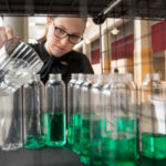 A girl pours bright green drinks